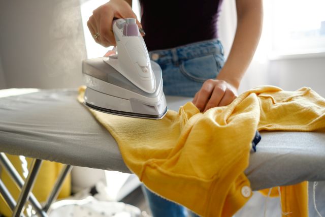 Kobieta prasująca żółtą koszulę