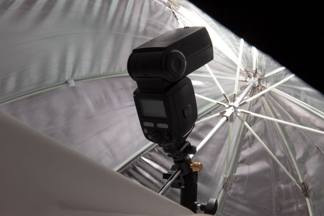 aparat z lampą na tle parasola fotograficznego