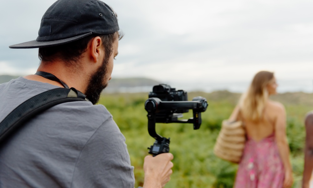 mężczyzna kręci film kamerą na gimbalu