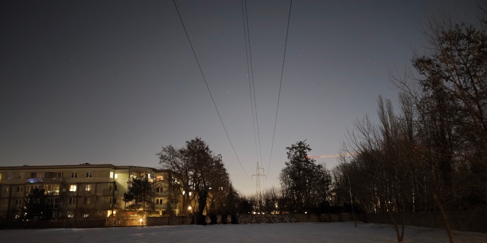 Zdjęcie nocne z Motoroli Signature z linią wysokiego napięcia i rozgwieżdżonym niebem.