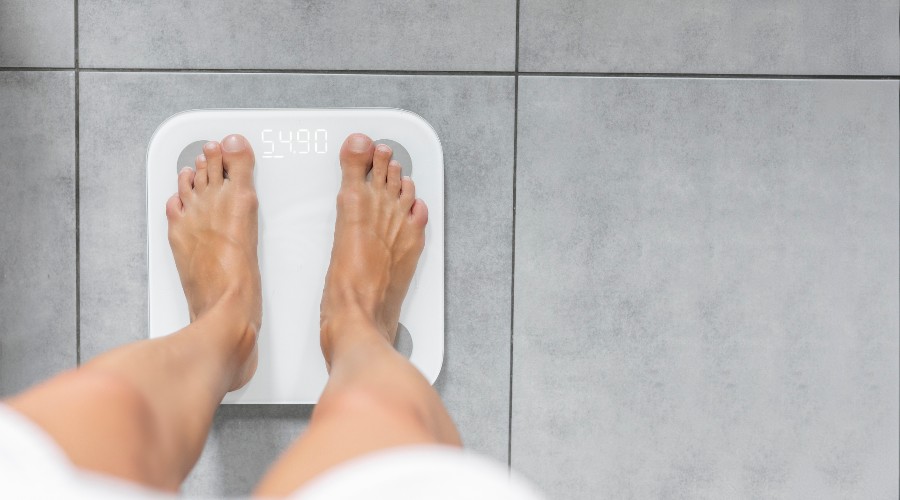 Mężczyzna mierzący tkankę tłuszczową na wadze łazienkowj