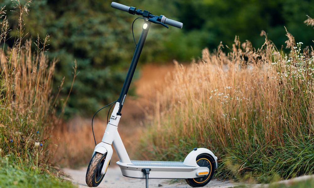 od ilu lat można jeździć na hulajnodze elektrycznej - biała hulajnoga stoi na ścieżce
