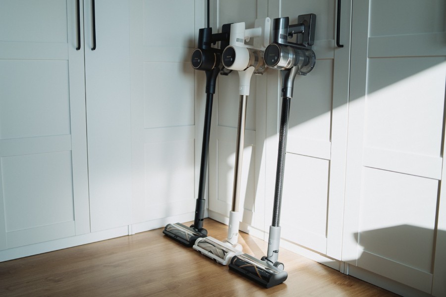 3 odkurzacze pionowe Dreame stoją oparte o szafę