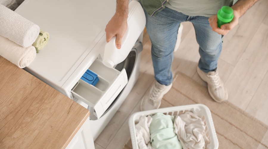 Mężczyzna sypiący proszek do pralki