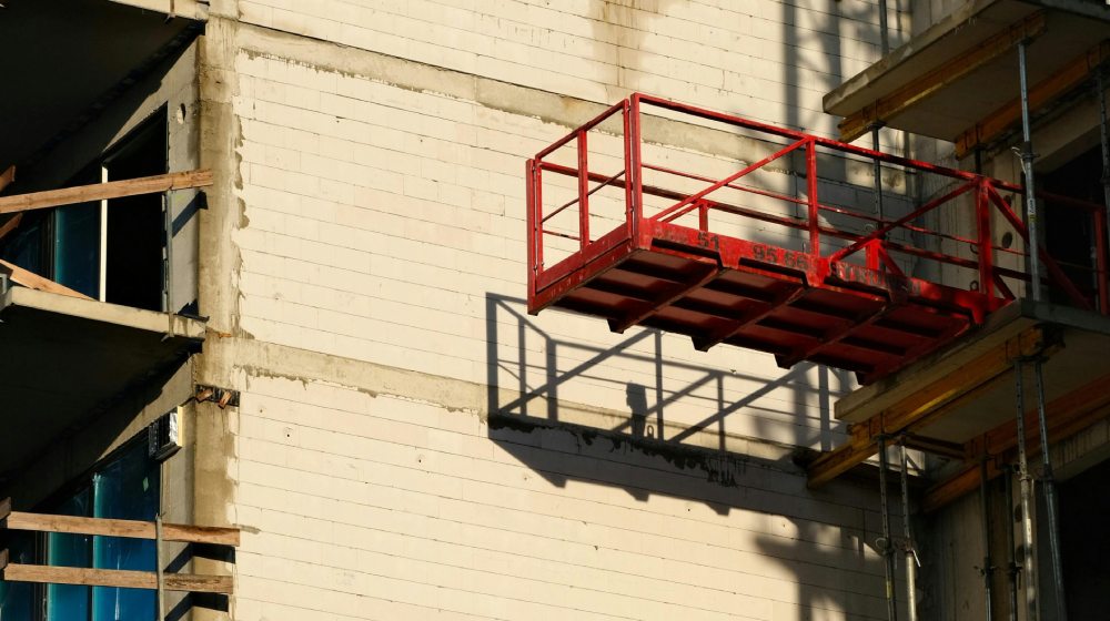 czerwony podest na ścianie budowanego bloku mieszkalnego