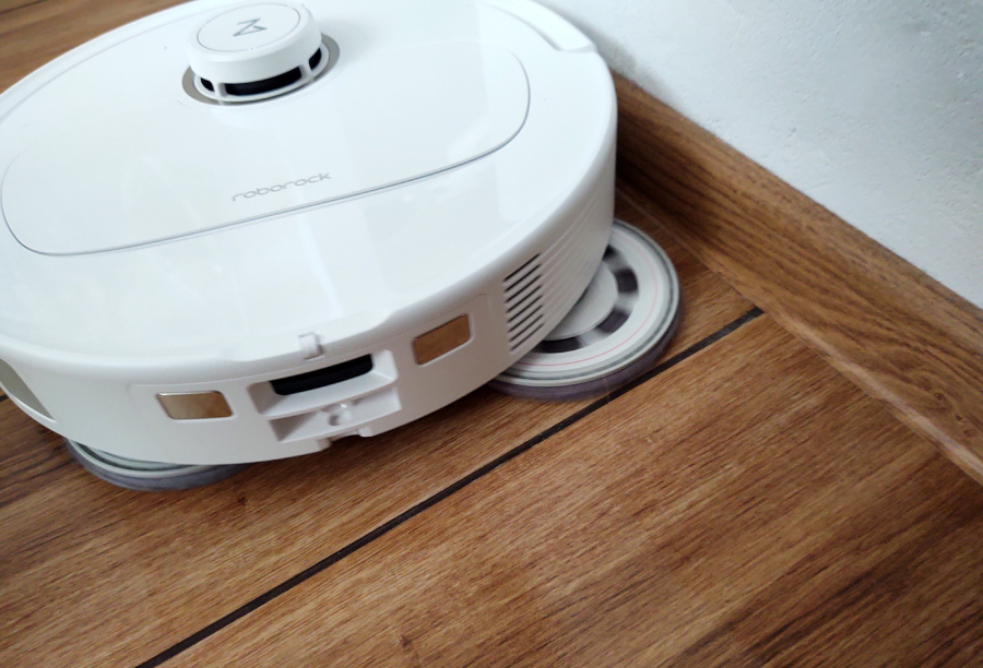 roborock qrevo jedzie przy scianie z wysuniętą n&oacute;żką do mopowania