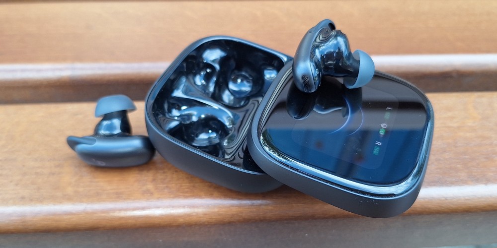 Słuchawki bezprzewodowe Soundcore Liberty 5 pro max leżą na ławce z etui obok.