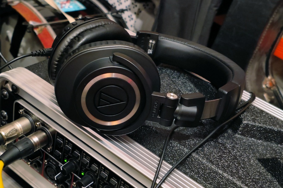 Słuchawki Audio-Technica ATH-M50xBT2 w studio nagraniowym leżą na zestawie interfejsów audio