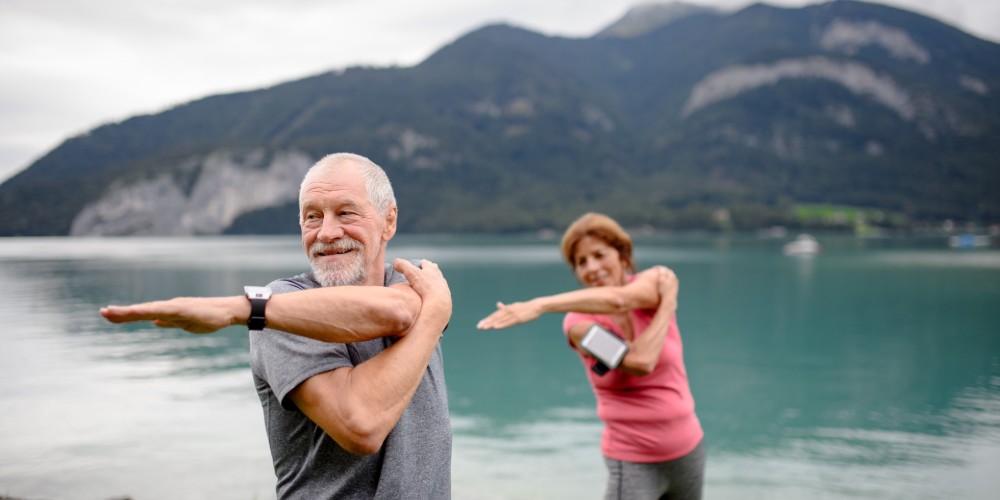 Ćwiczący seniorzy ze smartwatchami na nadgarstkach