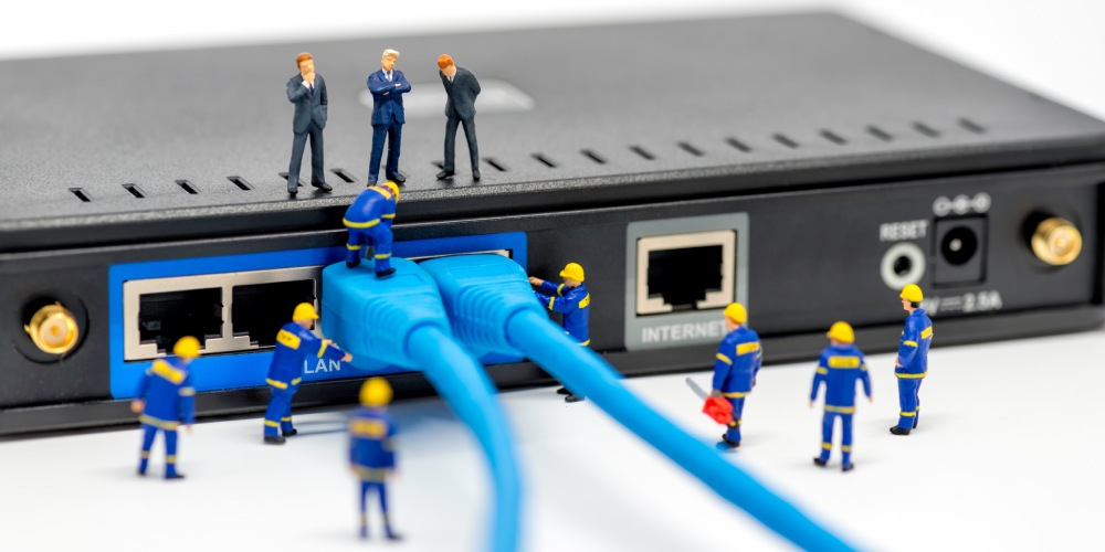 miniaturowe ludziki przy przełączniku sieciowym