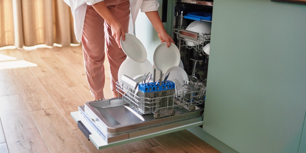 Kobieta wyciagająca naczynia ze zmywarki