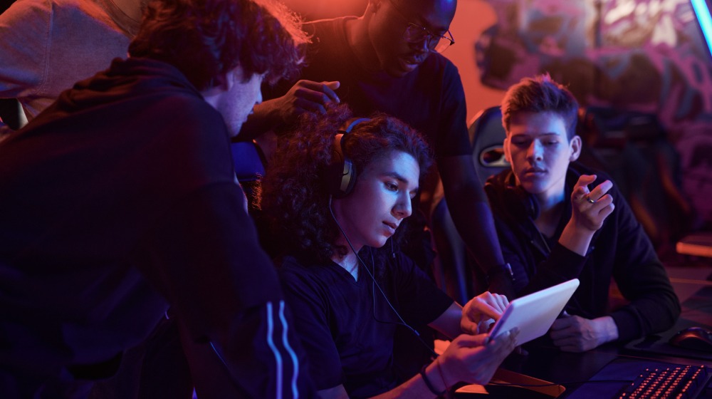 gracze patrzą się w ekran tabletu