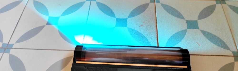 odkurzacz pionowy Dreame Z30 AquaCycle Pro - turkusowe światło odkurzacza podświetla kurz na podłodze w łazience