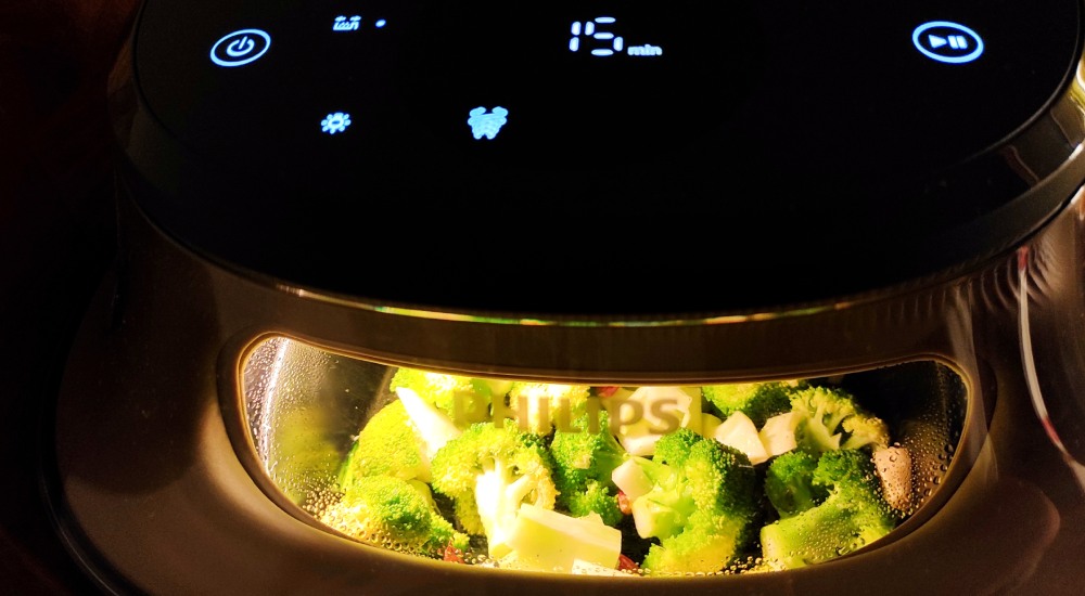 air fryer Philips Ovi NA547 - widok przez okienko urządzenia na brokuły w koszu