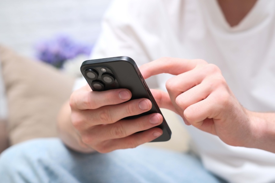 mężczyzna trzyma telefon w dłoni