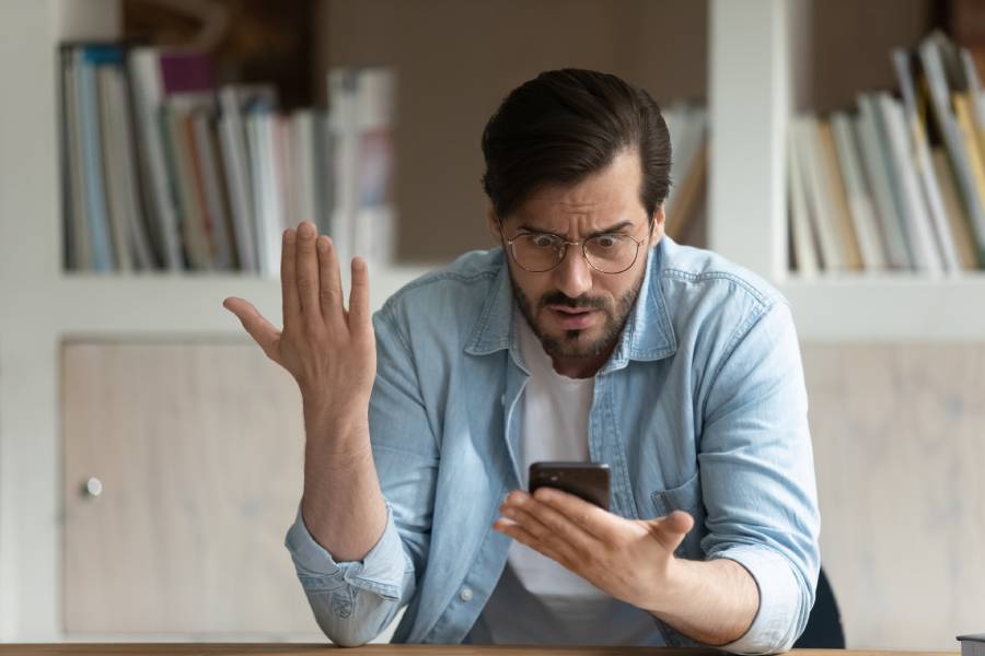 zdenerwowany mężczyzna trzyma telefon