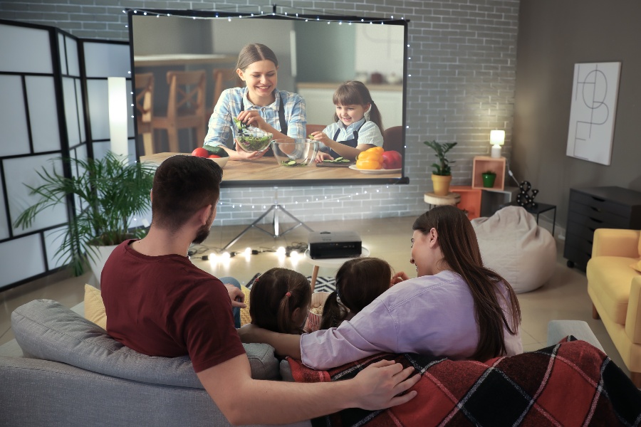 Rodzina oglądająca materiał na projektorze