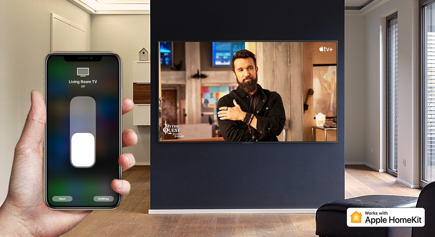 Zbliżenie ręki sterującej telewizorem za pomocą iPhone’a i telewizora, na którym wyświetlona jest treść z Apple TV+