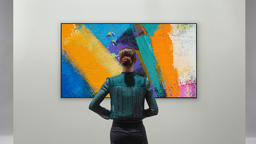 Kobieta koglądająca abstrakcyjne dzieło sztuki na telewizorze Design Gallery