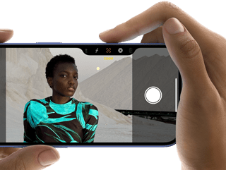 Użytkownik robi zdjęcie za pomocą trzymanego w dłoni iPhone’a 16