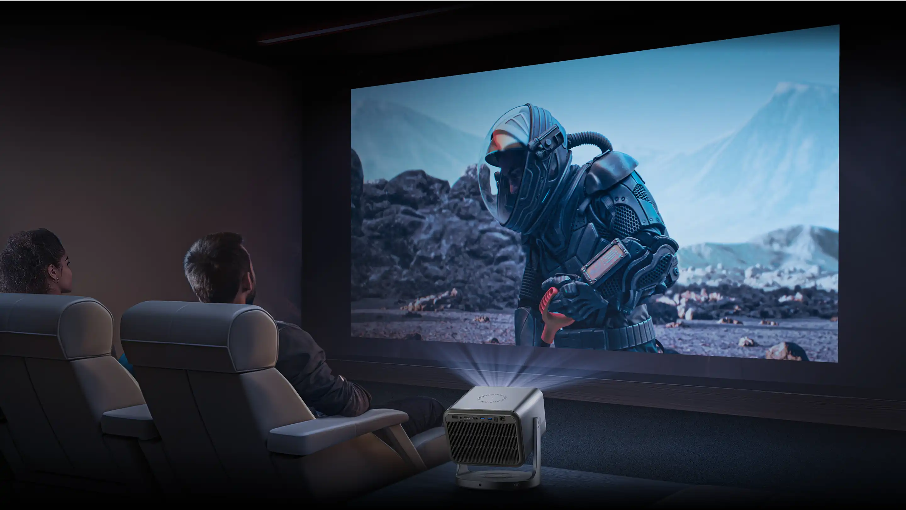 Dwie osoby siedzą w fotelach przed dużym ekranem, na którym wyświetlany jest z projektora film science fiction.