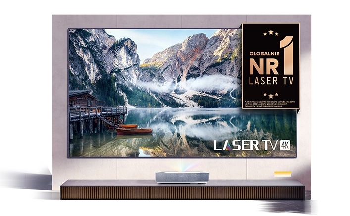 Laserowy telewizor z krajobrazem górskim na ekranie, ustawiony na szafce.