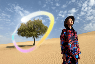 Widoczny od przodu iPad Pro, na ekranie wiele otwartych aplikacji na tle o gradiencie od ciemnoniebieskiego do zielonego. Dłoń trzyma rysik Apple Pencil Pro i zakreśla szkic, używając funkcji różdżki graficznej Apple Intelligence