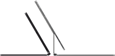 Dwa widoczne z boku smukłe iPady Pro podłączone do klawiatur Magic Keyboard, jednej w kolorze gwiezdnej czerni, nachylonej i półotwartej, z głośnikami i portem USB‑C, i drugiej w kolorze srebrnym, otwartej i nachylonej tak, że widać konstrukcję wspornika, głośników i mikrofonu