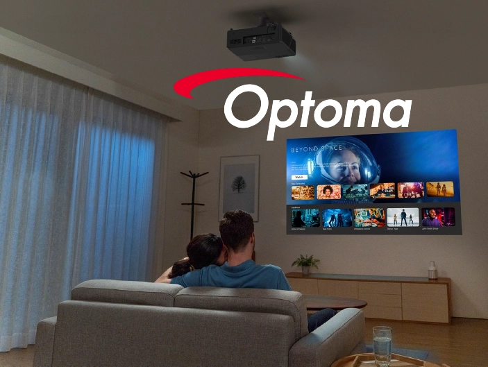 Para siedzi na sofie w nowoczesnym salonie, oglądając film wyświetlany na ścianie przez projektor sufitowy Optoma.