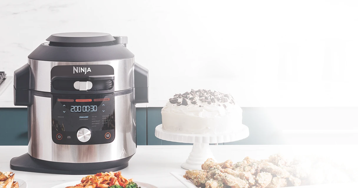 Multicooker Ninja Foodi Max OL750EU stojący obok białego tortu na blacie kuchennym