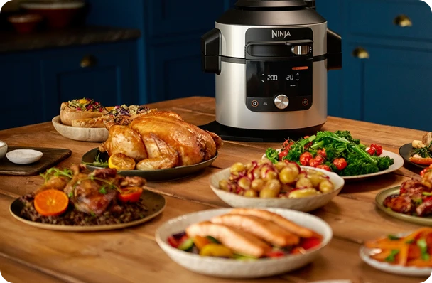 Multicooker Ninja Foodi Max na stole w otoczeniu rozmaitych potraw świątecznych