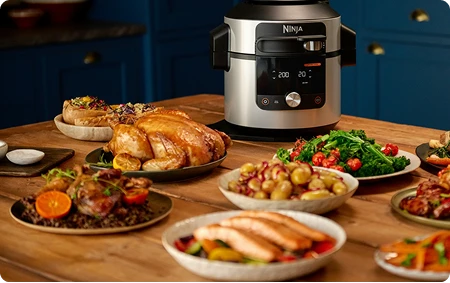Multicooker Ninja Foodi Max na stole w otoczeniu rozmaitych potraw świątecznych
