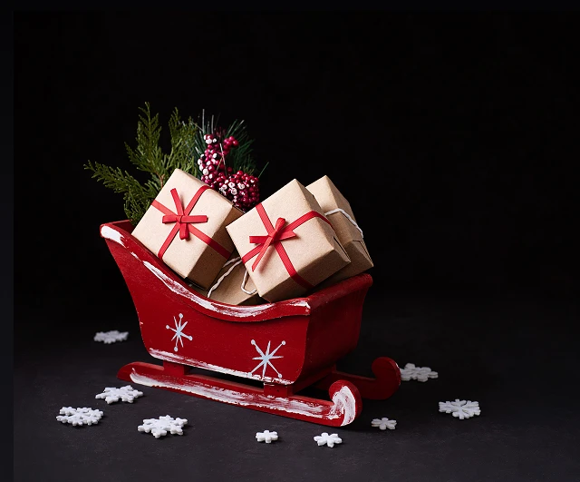 Małe ozdobne sanie Mikołaja, pełne pudełeczek z prezentami