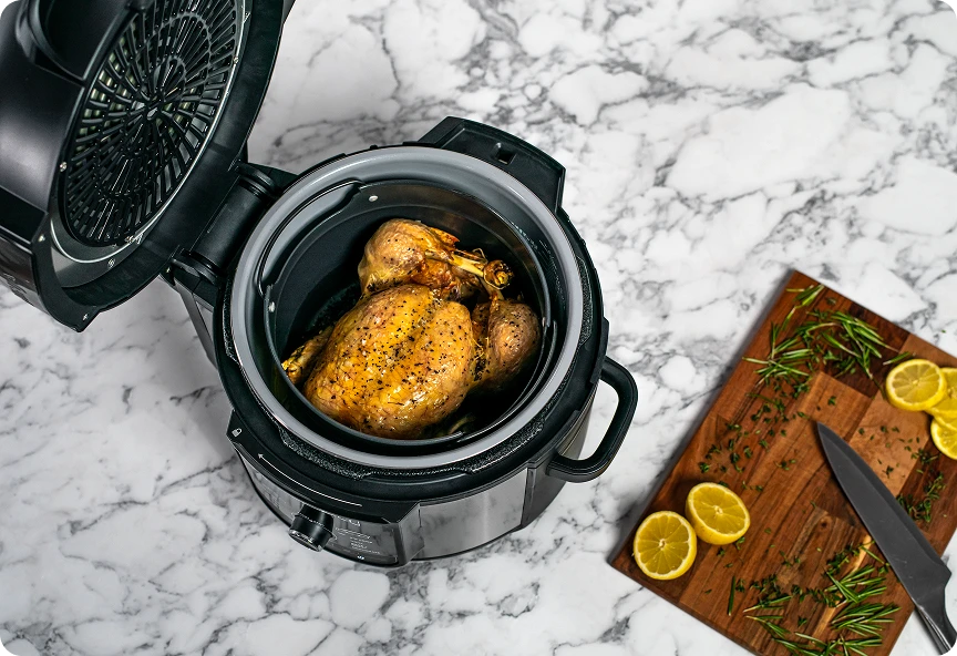 Widok od góry na otwarty Ninja Foodi Max OP500EU z kurczakiem w środku
