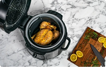 Widok od góry na otwarty Ninja Foodi Max OP500EU z kurczakiem w środku