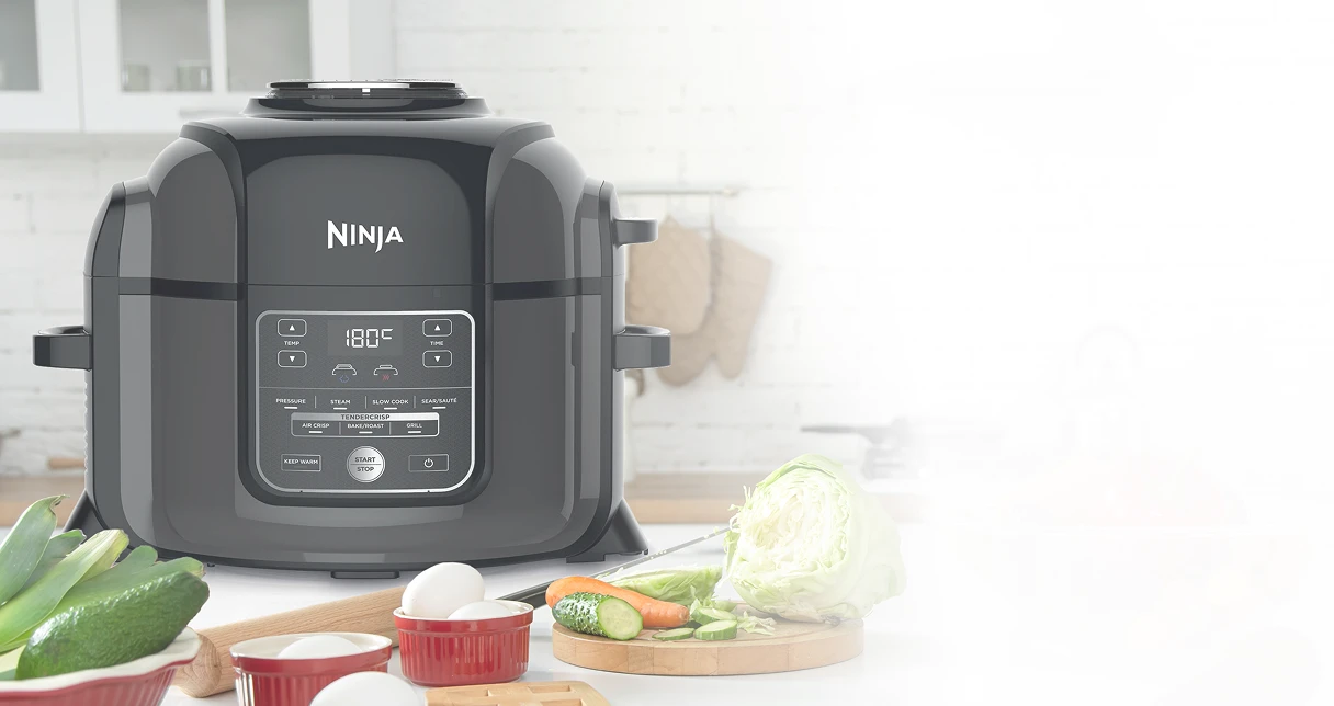 Ninja Foodi OP300EU stojący obok na blacie kuchennym w otoczeniu warzyw