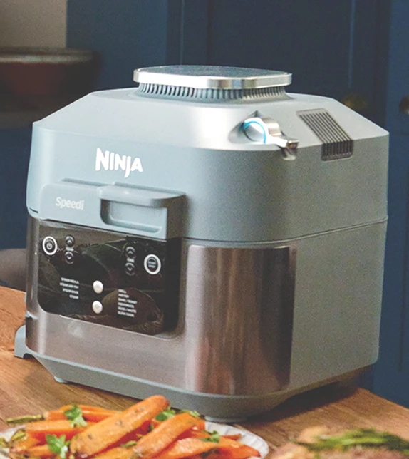 Ninja Speedi ON400EU stoi na stole w otoczeniu rozmaitych potraw świątecznych, pieczywa i ciast