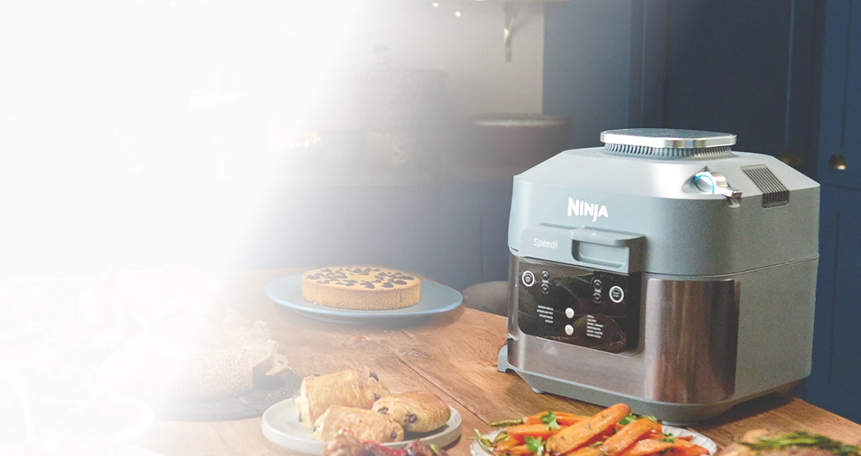 Ninja Speedi ON400EU stoi na stole w otoczeniu rozmaitych potraw świątecznych, pieczywa i ciast