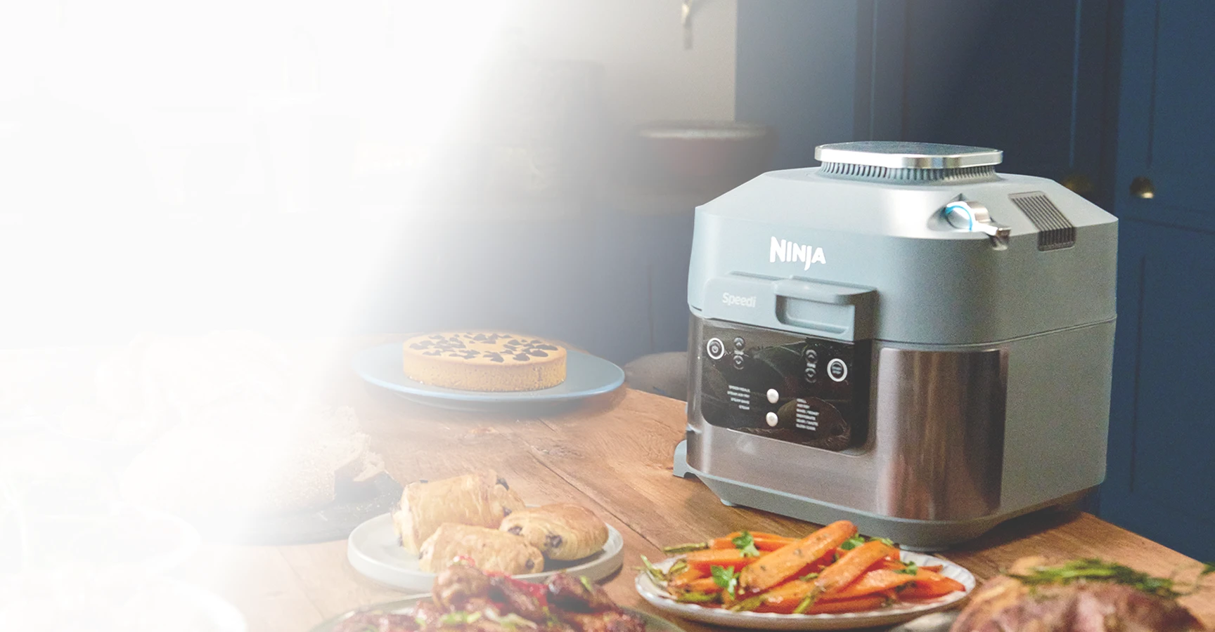 Ninja Speedi ON400EU stoi na stole w otoczeniu rozmaitych potraw świątecznych, pieczywa i ciast