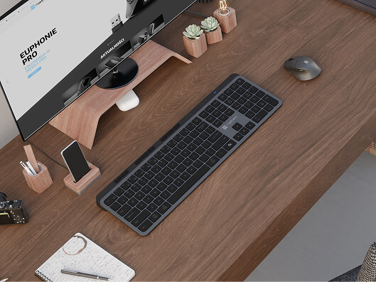 Biurko z bezprzewodową klawiaturą i myszą Natec, monitorem na drewnianej podstawce oraz drobnymi akcesoriami