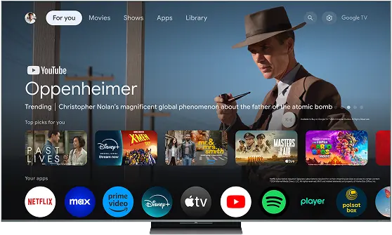 Ekran telewizora z interfejsem Google TV, wyświetlający różne polecane filmy i aplikacje, w tym film Oppenheimer