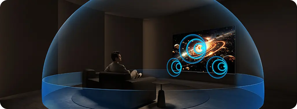 Mężczyzna siedzi na sofie, oglądając na dużym ekranie galaktykę. Wizualizacja przestrzennego dźwięku 3D otacza widza.