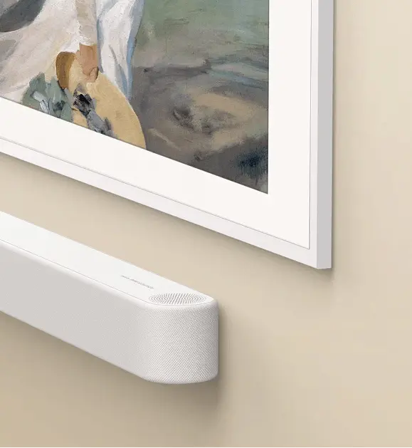 Biały soundbar Bang & Olufsen pod telewizorem z baletnicami na ekranie w jasnym minimalistycznym salonie