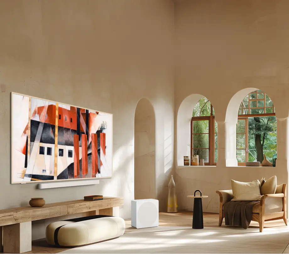Telewizor TCL z abstrakcyjnym obrazem w beżowym minimalistycznym salonie z łukowymi oknami i rattanowym fotelem