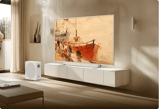 Telewizor TCL z abstrakcyjnym obrazem łodzi na białej szafce RTV z subwooferem w jasnym salonie z zasłonami