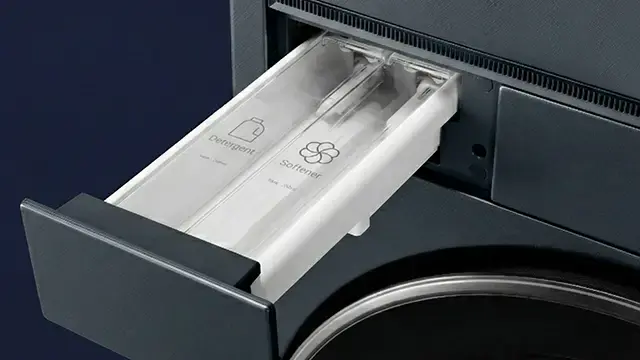 Szuflada na detergent i płyn do płukania wysunięta z pralki.