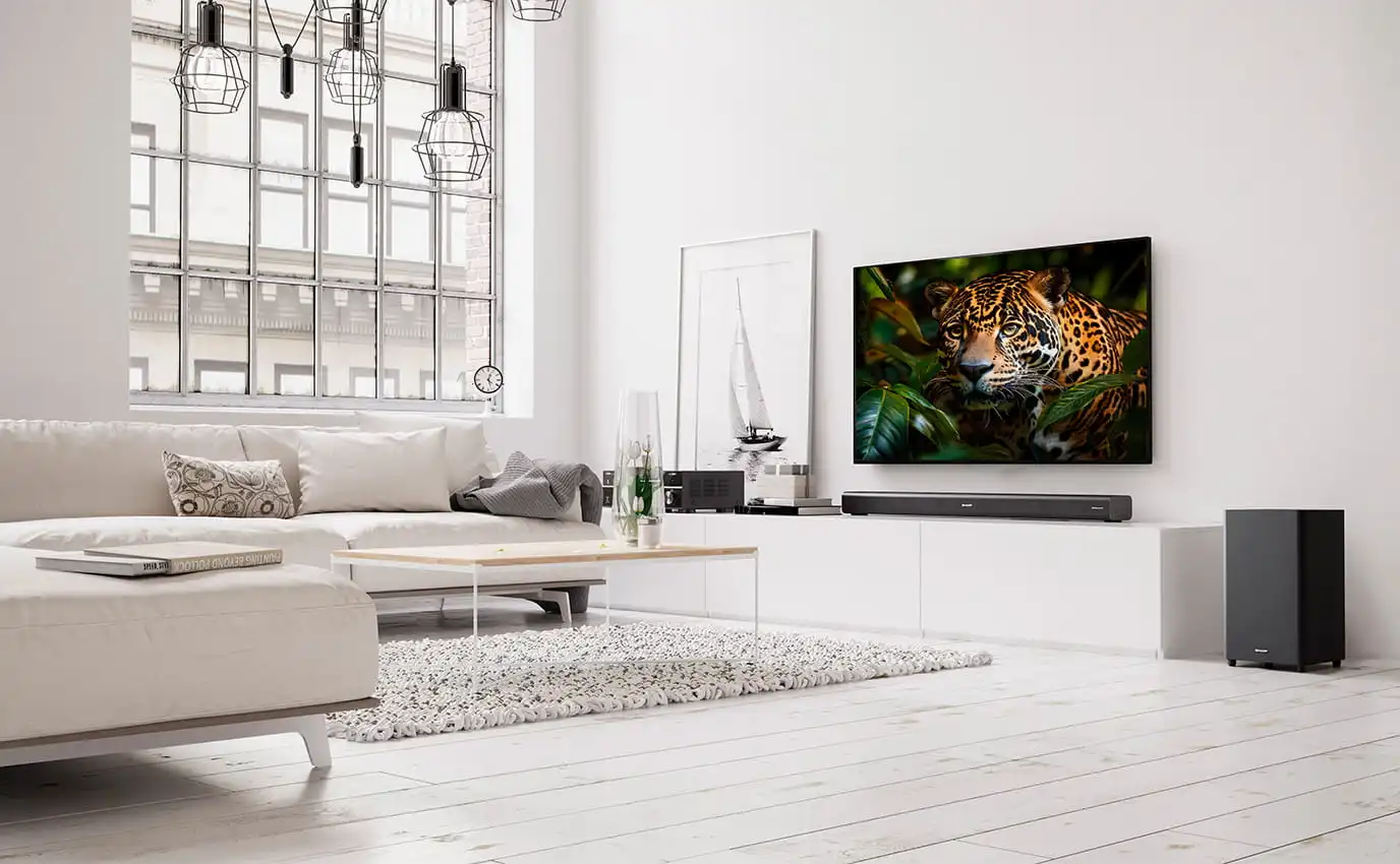 Nowoczesny, jasny salon z telewizorem zamontowanym na ścianie, na którym wyświetlany jest obraz lamparta.