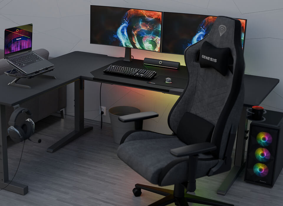 Czarne biurko narożne z laptopem na podstawce, podwójnym monitorem, fotel gamingowy i PC z RGB