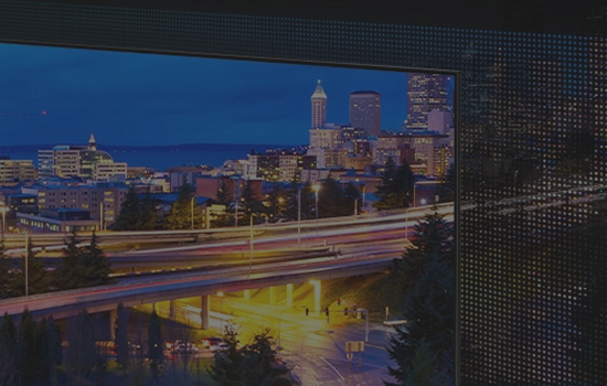 Widok na rozświetlone miasto wczesnym wieczorem.