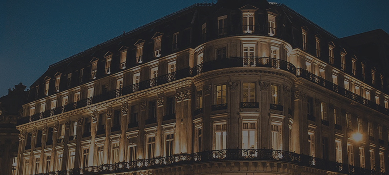 Fasada eleganckiego budynku przy zapadającym zmroku.